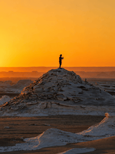 Solitary explorer in desert sunset